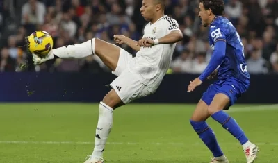 Kylian Mbappé intenta dominar el balón con la marca de Luis Milla.