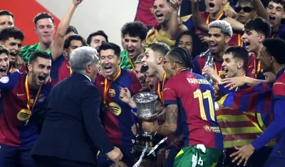 El presidente del FC Barcelona Joan Laporta, los jugadores y cuerpo técnico celebran la victoria con el trofeo