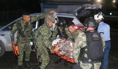 Integrantes de las Fuerzas Militares trasladando a una persona herida este jueves.