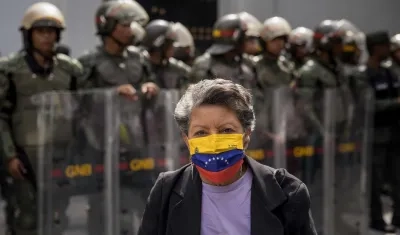Mujer usando una mascarilla con la bandera de Venezuela. 