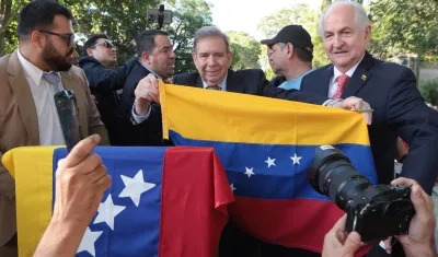 Edmundo González sostiene la bandera de Venezuela en Montevideo, Uruguay.