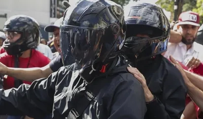 María Corina Machado (de casco negro) retirándose de la manifestación de este jueves.