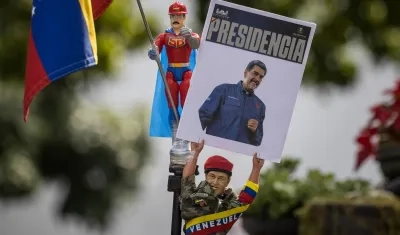 Muñeco del fallecido presidente, Hugo Chávez, con un cartel del presidente de Venezuela, Nicolás Maduro. 