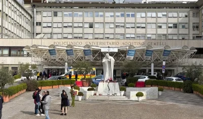 Velas y flores a los pies de la escultura de Juan Pablo II a las puertas del Hospital Gemelli