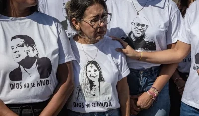 Personas portan camisetas con imágenes de sus familiares detenidos durante una manifestación.