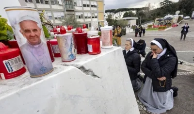 Dos monjas rezan bajo la estatua del Papa Juan Pablo II, en el policlínico Gemelli.