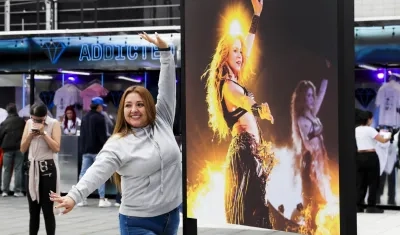 Una seguidora de Shakira posa junto a una foto de la cantante barranquillera. 