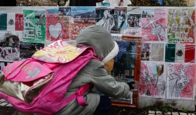Un niño mira dibujos y fotografías colocadas en la parte inferior de la estatua de Juan Pablo II junto al Hospital Gemelli.