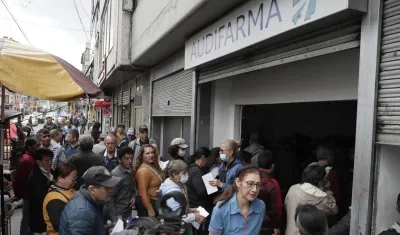 Largas filas para reclamar medicamentos en una droguería de Audifarma. 