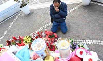 Un hombre reza junto a la estatua de Juan Pablo II en el hospital Gemelli, en Roma.