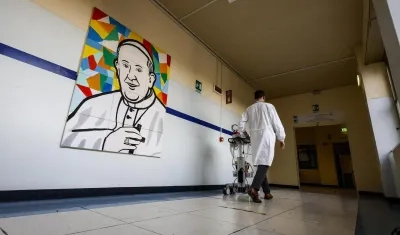 Un médico pasa junto a un mural que representa al Papa Francisco dentro del Hospital Gemelli.