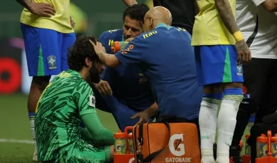 Alisson Becker recibe atención médica tras chocar con el colombiano Dávinson Sánchez. 