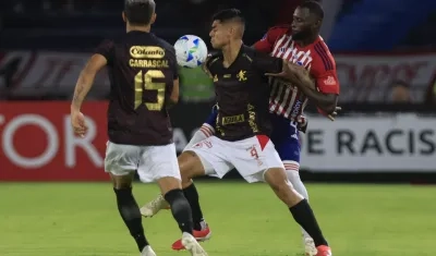 José Cuenú disputa la pelota con el delantero peruano Luis Ramos. 