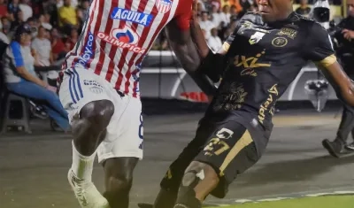 Yimmi Chará disputa la pelota con Duván Mosquera, de Llaneros. 