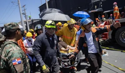 Mujer herida es evacuada por los equipos de rescate.