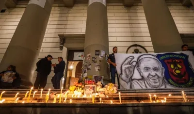 Personas encienden velas durante un homenaje al papa Francisco en la Catedral de Buenos Aires. 