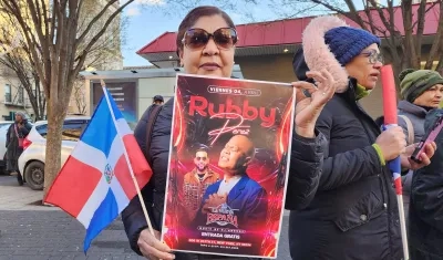 Mujer sosteniendo un cartel del cantante Rubby Pérez.