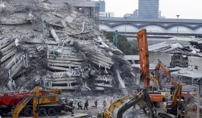 Rescatistas realizan labores de búsqueda en medio de los escombros.