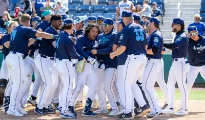 El colombiano Michael Arroyo es felicitado por sus compañeros tras llegar al plato. 