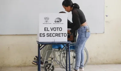 Un hombre en silla de ruedas marca su voto en un centro de votación este domingo, en Olón.