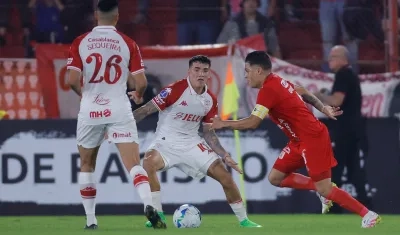 Juan Fernando Quintero intenta avanzar ante la marca de Rodrigo Cabral, de Huracán.
