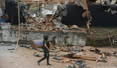 Un policía camina frente a la estación afectada por una explosión en Mondomo, Cauca.