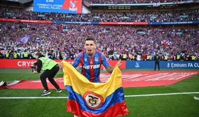 Daniel Muñoz celebrando el título con la bandera colombiana.