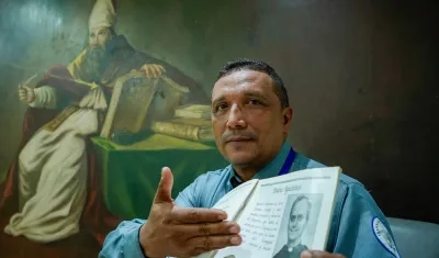 Jairo Enrique Padilla San Juan, guardia de seguridad del Colegio Liceo de Cervantes, junto al anuario del 2002 cuando el Papa León XIV visitó la institución.