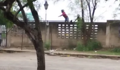 Momento en que varios hombres lanzaban piedras al parqueadero externo de la Universidad del Atlántico. 