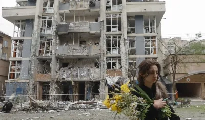 Mujer caminando junto a un edificio destruido tras el ataque nocturno. 