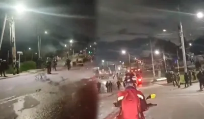 Los vándalos enfrentándose con la Policía esta noche en Bogotá. 