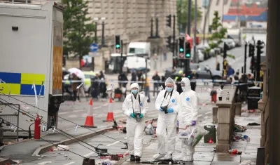 Oficiales forenses en el lugar donde un carro colisionó con personas durante el desfile del trofeo del Liverpool FC.