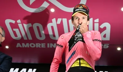 El británico Simon Yates en el podio con la maglia rosa. 