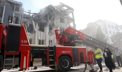 Los bomberos trabajan en un edificio alcanzado por ataques aéreos israelíes en el centro de Teherán.