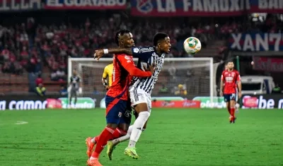 Jhon Navia disputa la pelota con José Ortiz, del Medellín. 