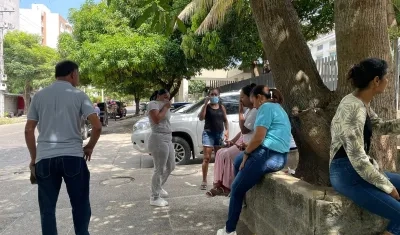 Personas en las afueras de la morgue se cubren ante el putrefacto olor que emana de la parte interior. 