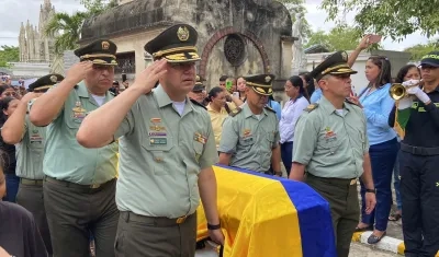Féretro siendo cargado por uniformados de la Policía.