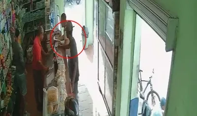 Momentos en que el joven dejaba un panfleto en una tienda en la tarde