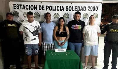 Cinco de los capturados y las joyas que mostró la Policía.