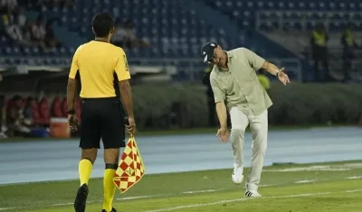 El técnico del Junior, Alfredo Arias, le reclama una jugada al árbitro asistente. 