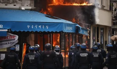 Agentes de policía aseguran alrededor de un restaurante en Paris tras ser incendiado.