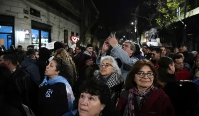 Personas se reúnen a esperar los resultados de las elecciones legislativas de la provincia de Buenos Aires frente a la casa de la expresidenta Cristina Fernández, este domingo, en Buenos Aires.