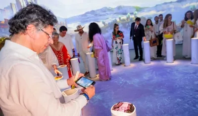 El Presidente Gustavo Petro tomando una imagen una lechona.