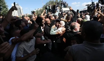La gente saluda a los presos palestinos liberados a su llegada a Ramala.