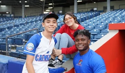 El pelotero Dilson Herrera con dos aficionados. 