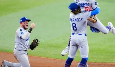 Mookie Betts, Kiké Hernández y Miguel Rojas celebran tras sacar el último out del juego. 