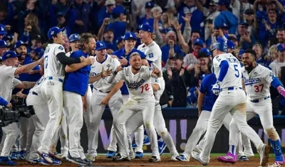 Freddie Freeman es esperado en el plato por sus compañeros para celebrar.