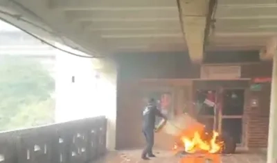 Personal de Uniatlántico mientras controla el incendio con un extintor.