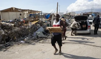 Personas afectadas por el paso del huracán Melissa recolectan objetos en Black River (Jamaica).
