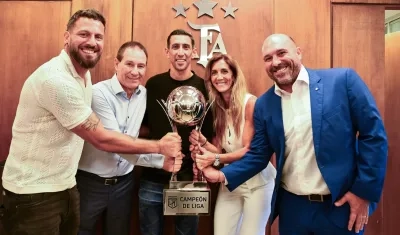 El técnico Ariel Holan, los jugadores Ángel Di María y Jorge Broun y el presidente Gonzalo Belloso posan con el trofeo. 